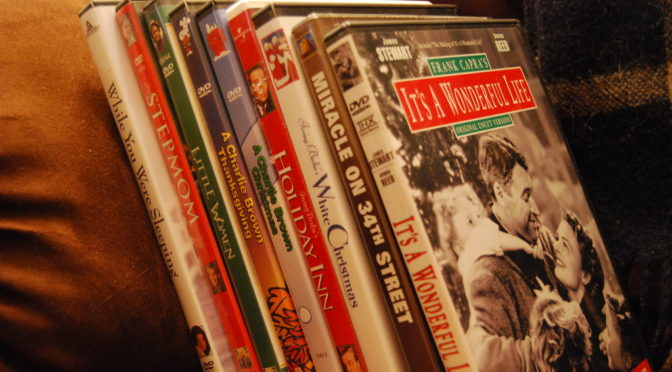 A stack of Christmas DVDs leaning on a couch